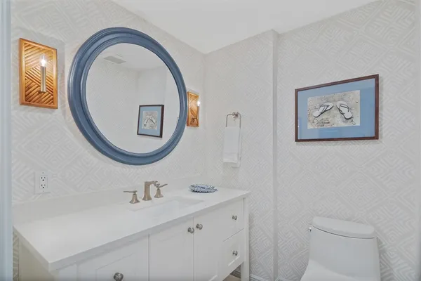 a bathroom with a toilet a sink and a mirror