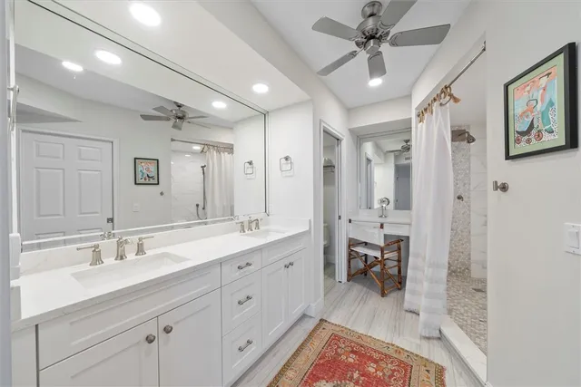 a en suite bathroom with a double vanity sink a toilet a mirror and shower