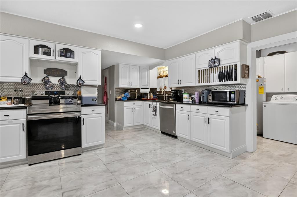 9727 Bear Lake Road Apopka, FL 32703 - Photo 12 of 22 a kitchen with stainless steel appliances granite countertop a stove top oven and cabinets