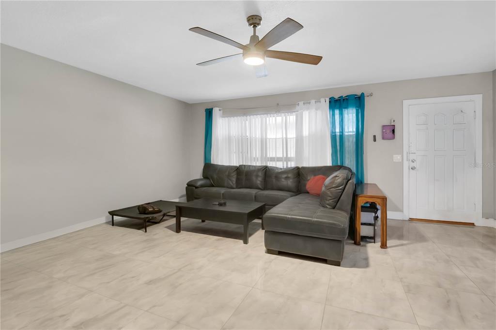 9727 Bear Lake Road Apopka, FL 32703 - Photo 4 of 22 a living room with furniture ceiling fan and a window