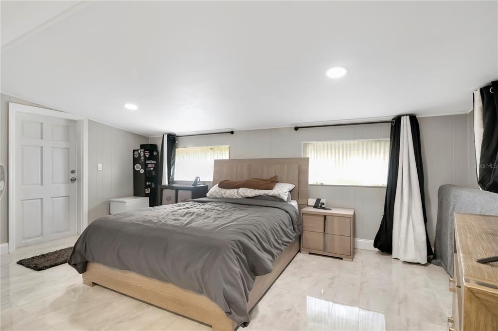 9727 Bear Lake Road Apopka, FL 32703 - Photo 5 of 22 a bedroom with a bed and a large mirror next to a window
