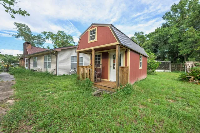 a view of backyard of house with green space