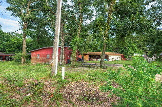 a view of a house with backyard and trees