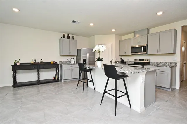 a kitchen with stainless steel appliances kitchen island a refrigerator and a stove top oven