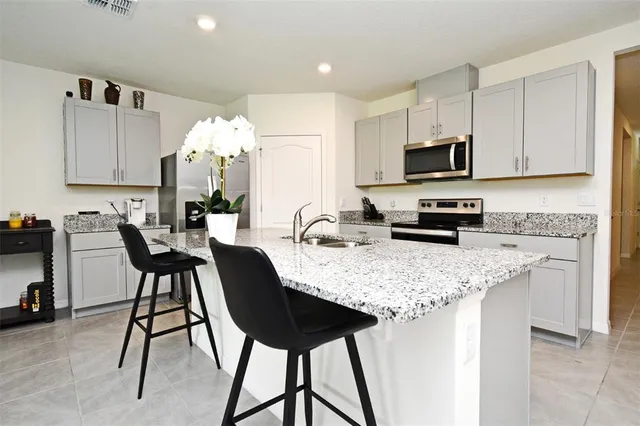 a kitchen with kitchen island granite countertop a table and chairs in it