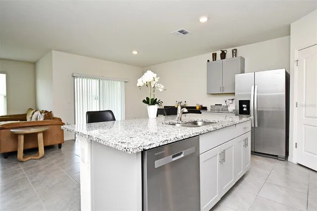 a kitchen with cabinets and chairs