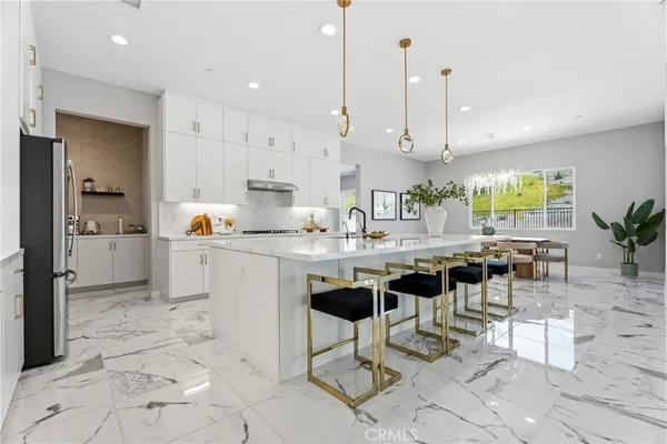 a kitchen with stainless steel appliances granite countertop a sink refrigerator and cabinets
