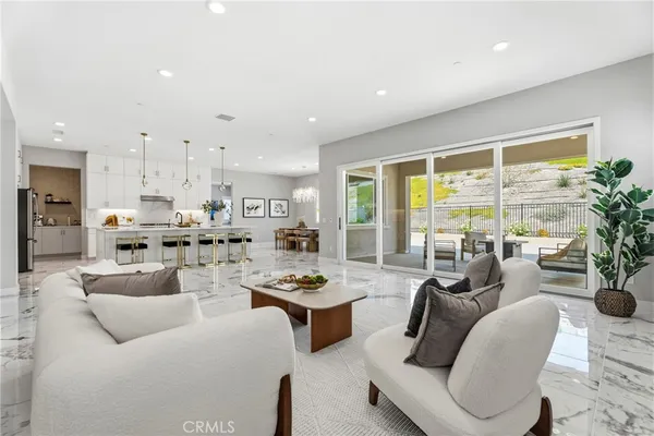 a dining room with kitchen island a chandelier a stove a table and chairs
