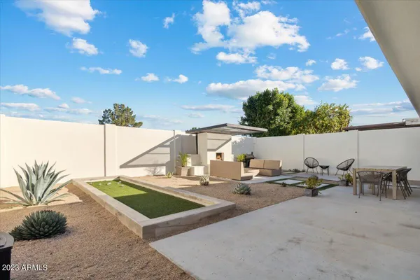 a backyard of a house with table and chairs