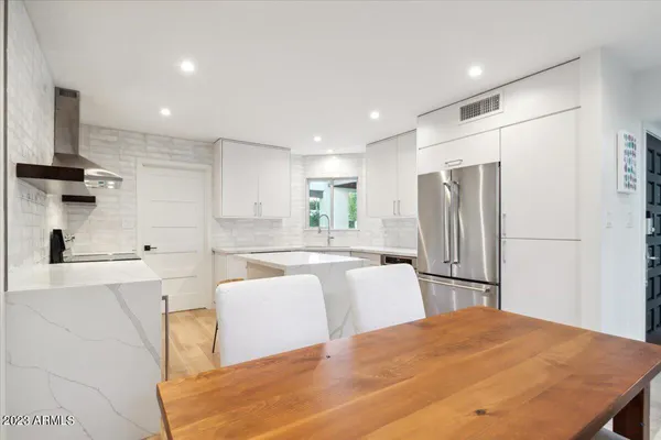 a kitchen with stainless steel appliances a refrigerator and a stove top oven