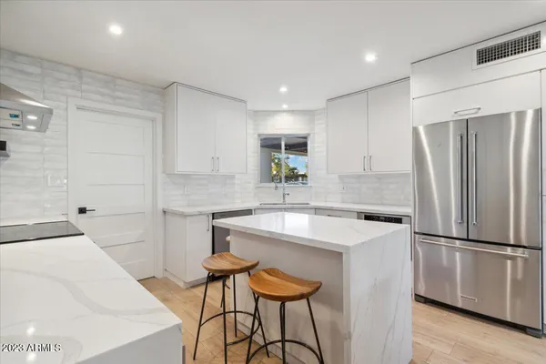 a kitchen with stainless steel appliances a refrigerator and a stove top oven