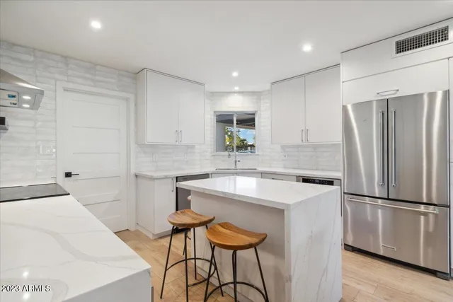 a kitchen with stainless steel appliances a refrigerator and a stove top oven