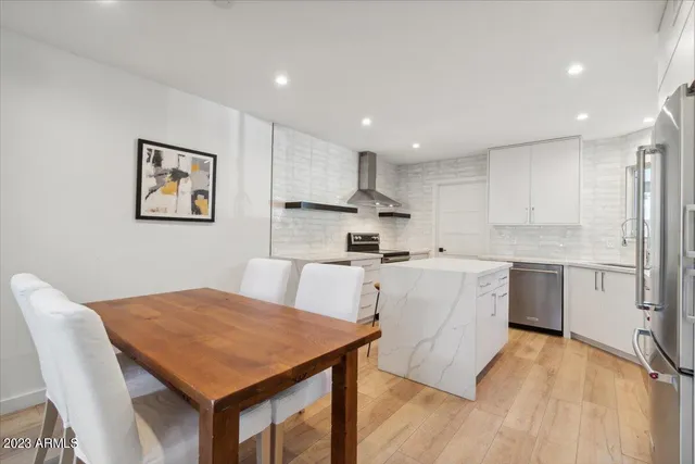 a kitchen with a table chairs a sink a counter top space and cabinets