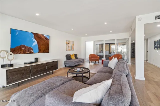 a living room with furniture ceiling fan and a flat screen tv