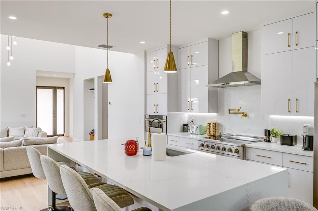 3384 Canal Street Naples, FL 34112 - Photo 13 of 34 a kitchen with stainless steel appliances kitchen island granite countertop a sink a stove a refrigerator and white cabinets