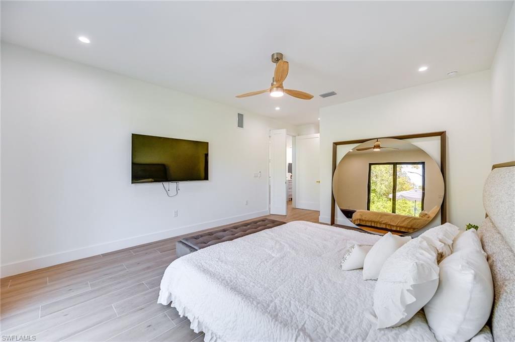 3384 Canal Street Naples, FL 34112 - Photo 15 of 34 a bedroom with a bed and a flat screen tv