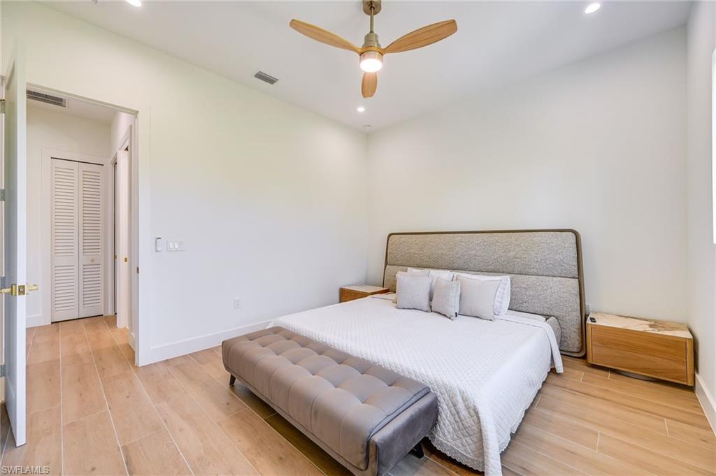 3384 Canal Street Naples, FL 34112 - Photo 19 of 34 a bedroom with a bed and wooden floor