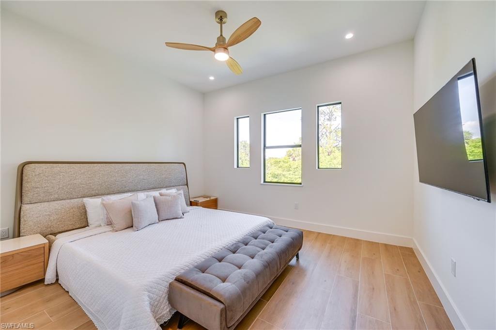 3384 Canal Street Naples, FL 34112 - Photo 20 of 34 a bedroom with a bed and a flat screen tv