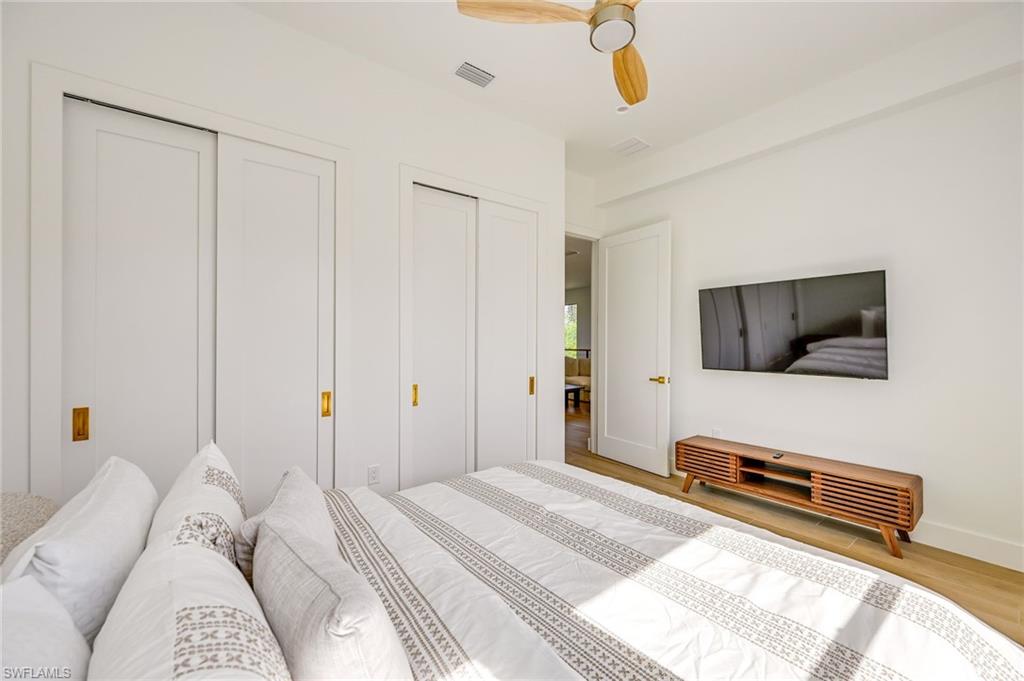 3384 Canal Street Naples, FL 34112 - Photo 21 of 34 a bedroom with a bed and flat screen tv