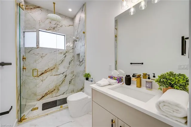 a bathroom with a sink a toilet and shower