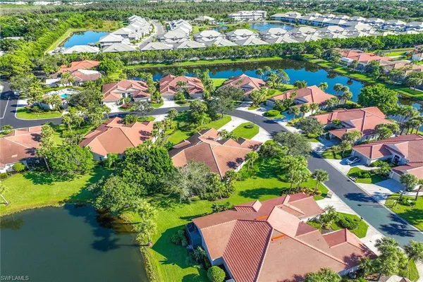 an aerial view of a house with swimming pool a yard and lake view