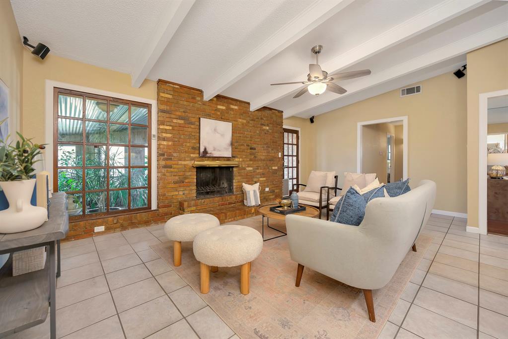 1761 Cynthia Lane Hurst, TX 76054 - Photo 16 of 40 a living room with furniture a fireplace and a chandelier