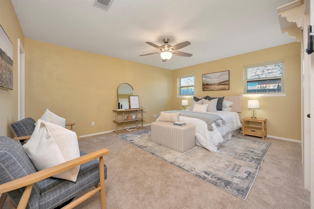 1761 Cynthia Lane Hurst, TX 76054 - Photo 24 of 40 a bedroom with a bed and a chandelier