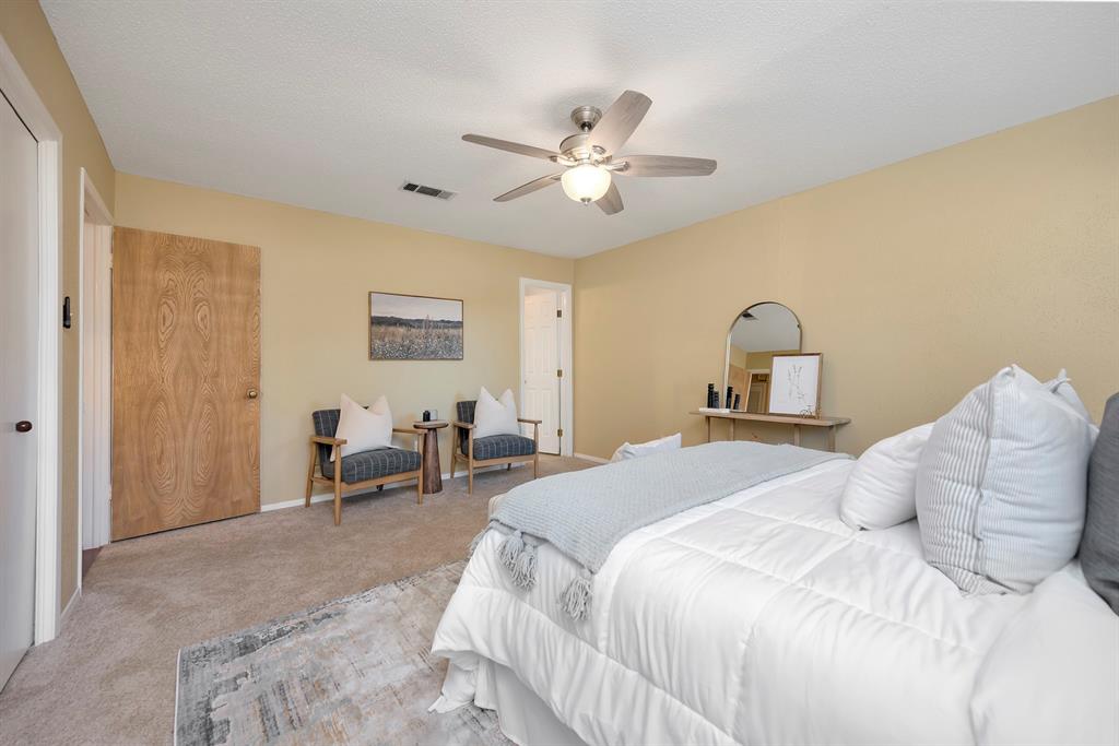 1761 Cynthia Lane Hurst, TX 76054 - Photo 27 of 40 a bedroom with a bed and a chandelier