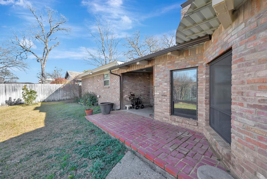1761 Cynthia Lane Hurst, TX 76054 - Photo 39 of 40 a view of a backyard with plants and wooden fence