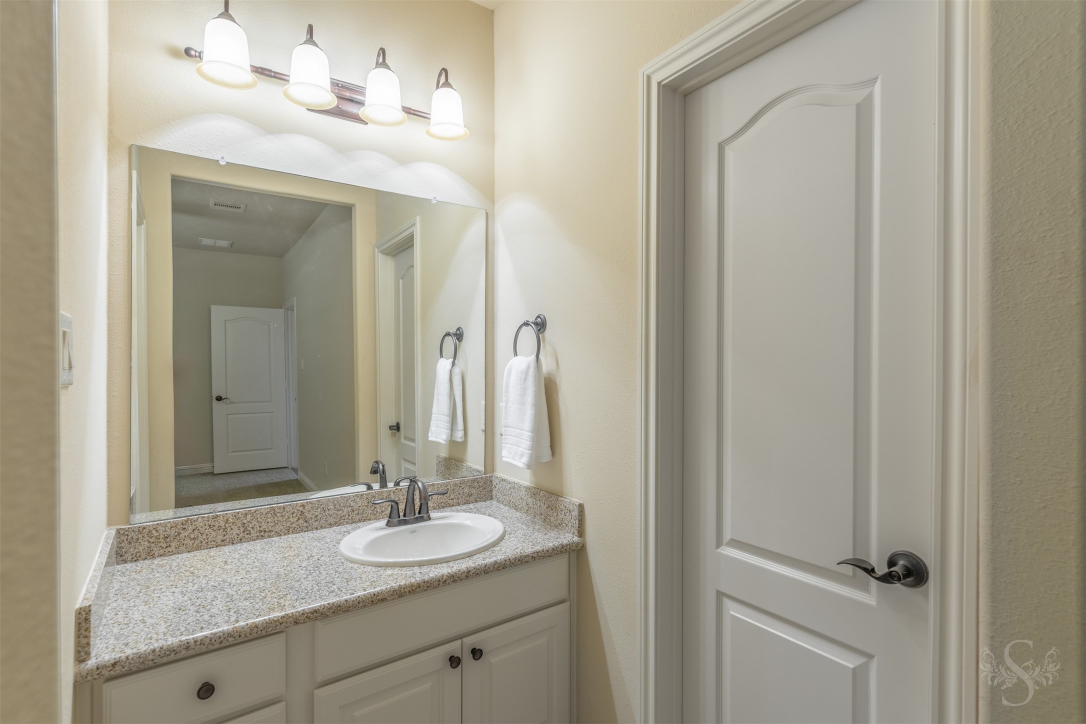 5803 Mustang Ridge Lane Fulshear, TX 77441 - Photo 30 of 48 Private en-suite bath features granite countertops, framed mirror and ample vanity storage. Thoughtfully designed for convenience, the space connects seamlessly to the secondary bedroom.