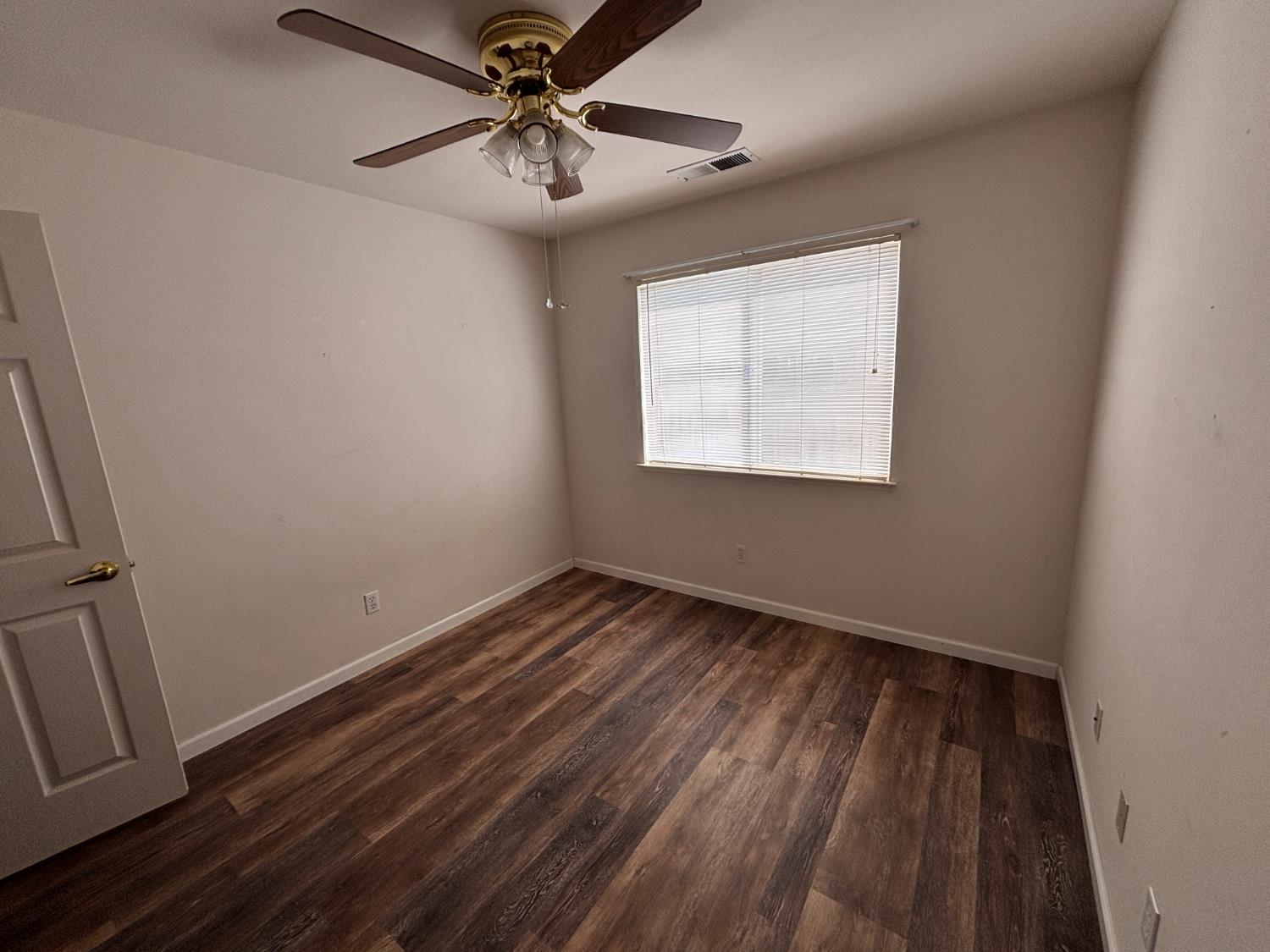 609 Merlot Avenue Madera, CA 93637 - Photo 18 of 45 an empty room with wooden floor fan and windows