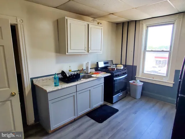 a kitchen with a sink cabinets and wooden floor