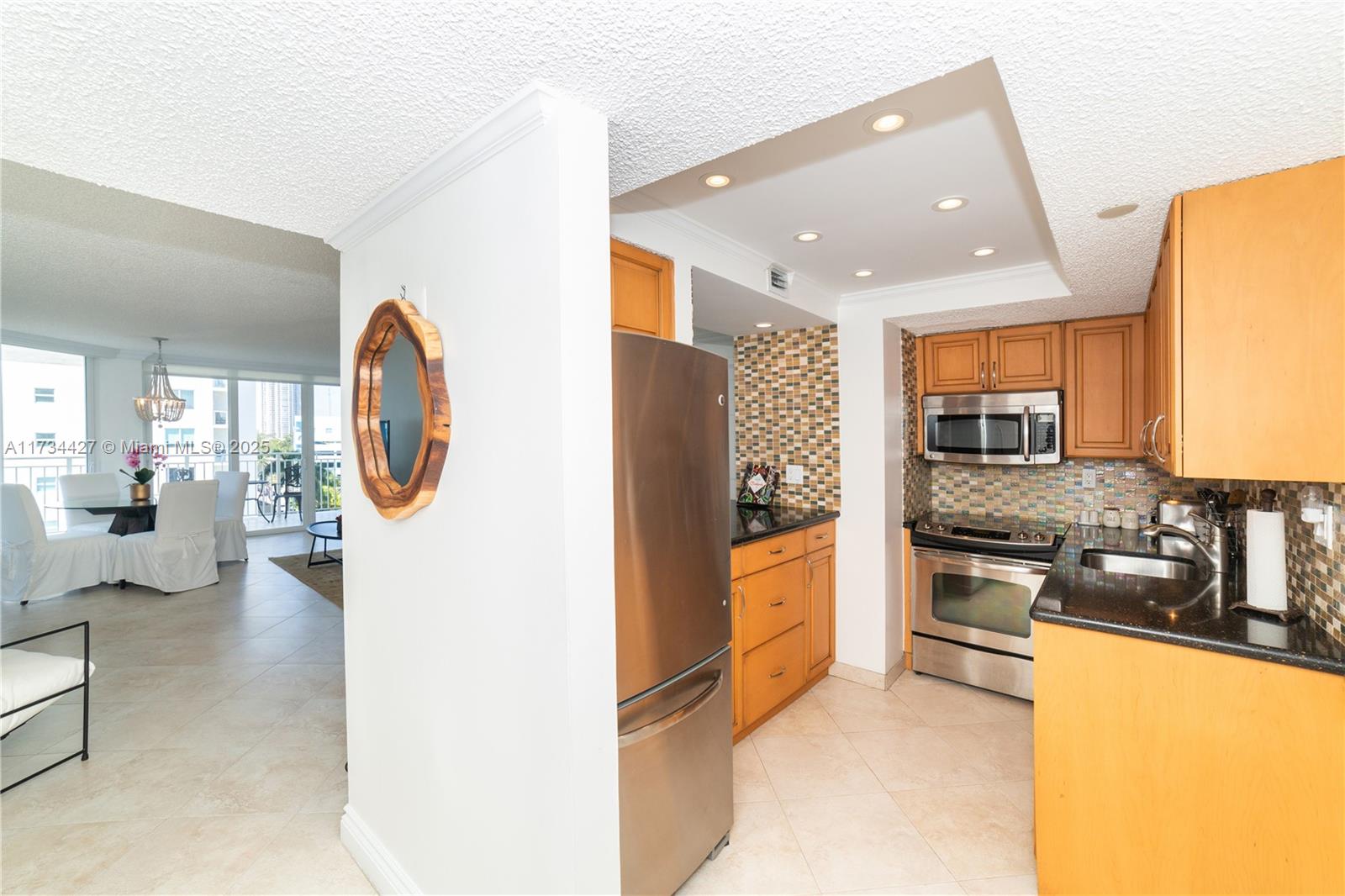 18000 North Bay Road, Unit 602 Sunny Isles Beach, FL 33160 - Photo 18 of 40 a kitchen with stainless steel appliances granite countertop a refrigerator and stove top oven