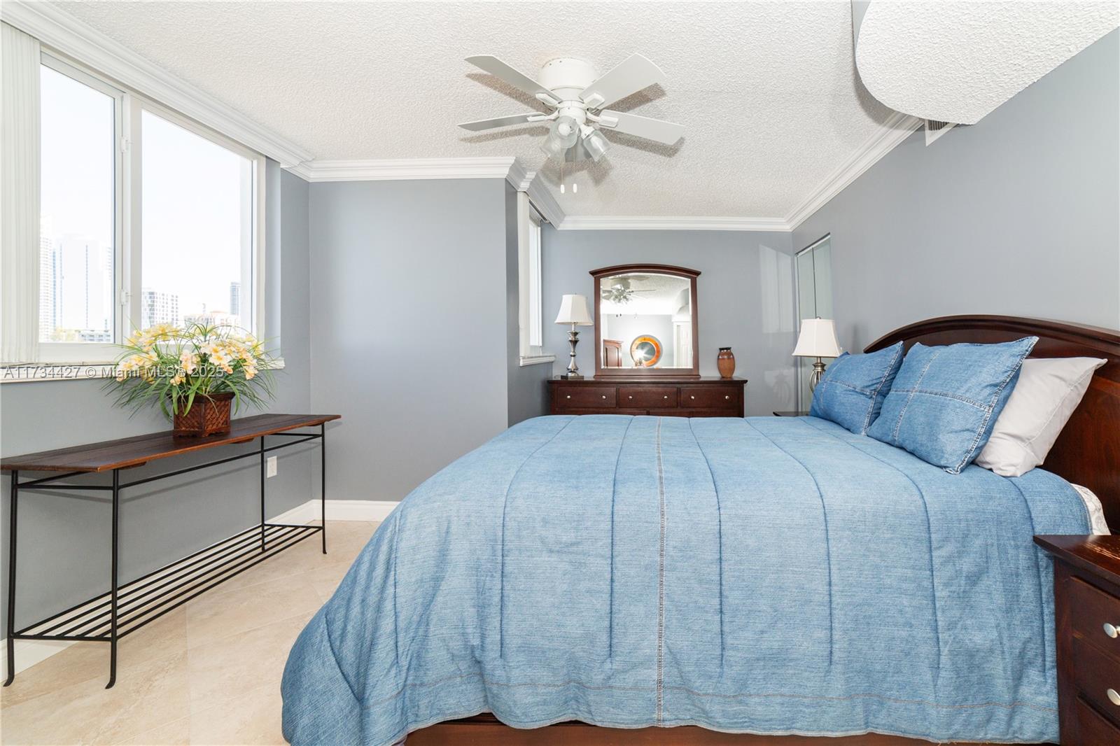 18000 North Bay Road, Unit 602 Sunny Isles Beach, FL 33160 - Photo 21 of 40 a bedroom with a bed and a chandelier