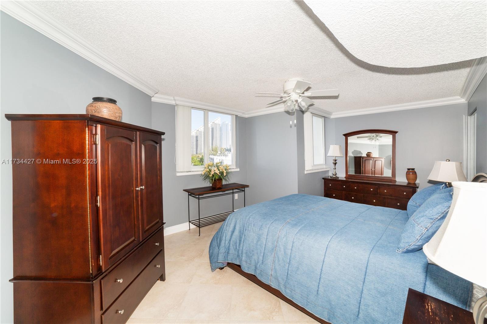 18000 North Bay Road, Unit 602 Sunny Isles Beach, FL 33160 - Photo 22 of 40 a bedroom with a bed and a chandelier
