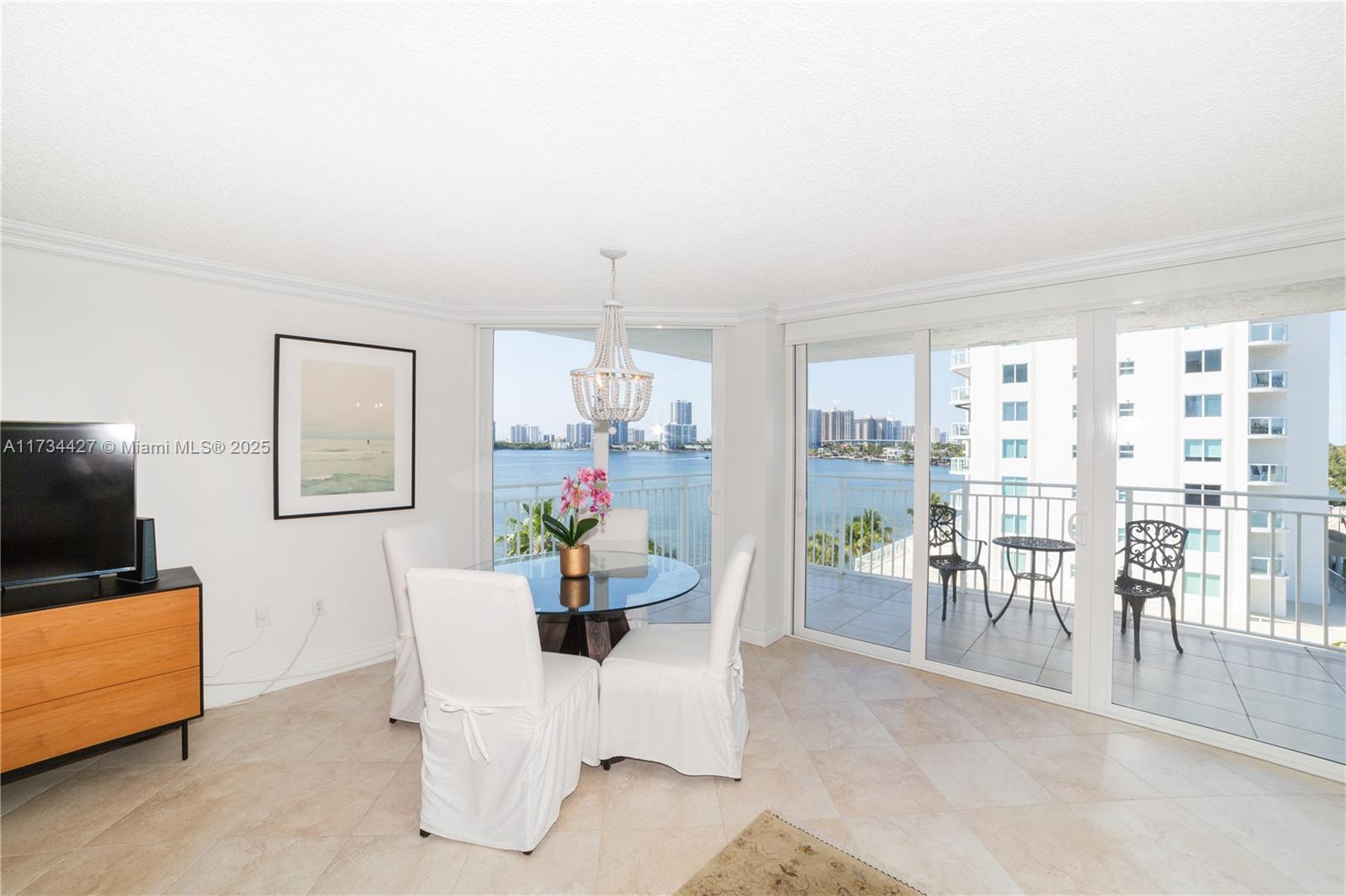 18000 North Bay Road, Unit 602 Sunny Isles Beach, FL 33160 - Photo 6 of 40 a dining room with furniture and a flat screen tv