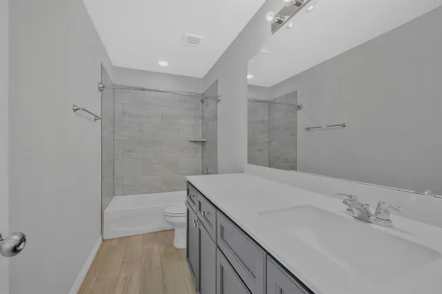 a bathroom with a sink a toilet and shower