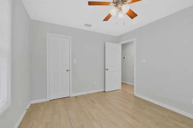a view of an empty room and chandelier fan