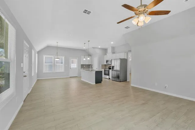 a view of a kitchen with a sink and a refrigerator