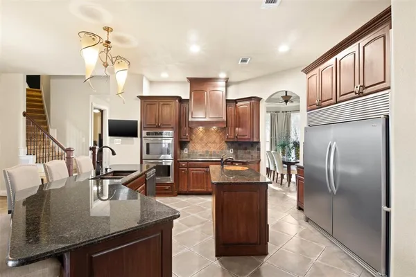 a kitchen with a table chairs refrigerator and microwave