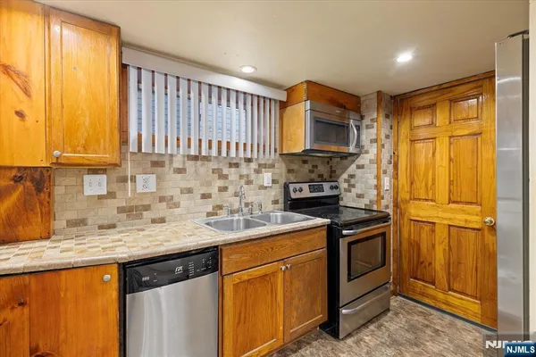 a kitchen with stainless steel appliances granite countertop a sink stove and cabinets