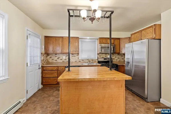 a kitchen with refrigerator a table and chairs