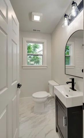 a bathroom with a sink toilet and a mirror