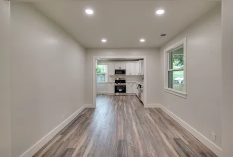 a view of a kitchen with wooden floor electronic appliances and window
