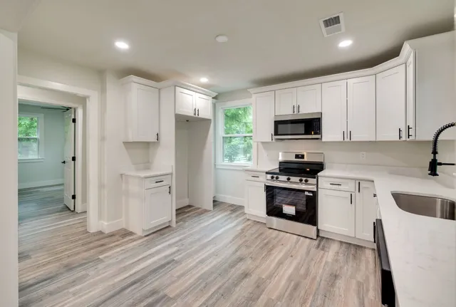 a kitchen with granite countertop a refrigerator stove and sink