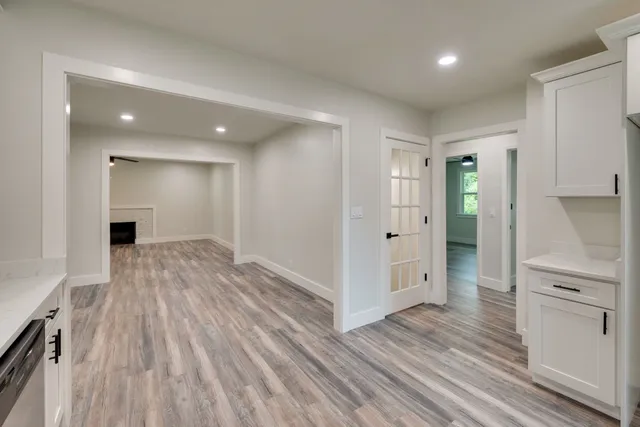 wooden floor in an empty room with kitchen view