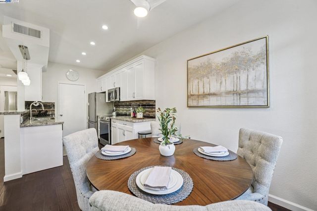 a dining room with furniture and a kitchen view