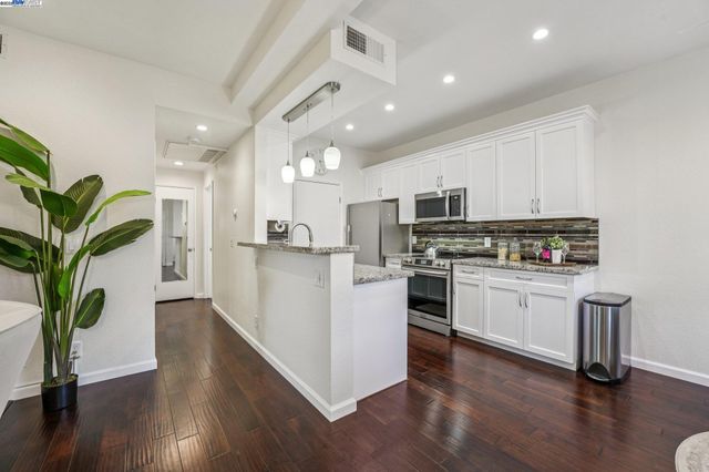 a kitchen with white cabinets and appliances