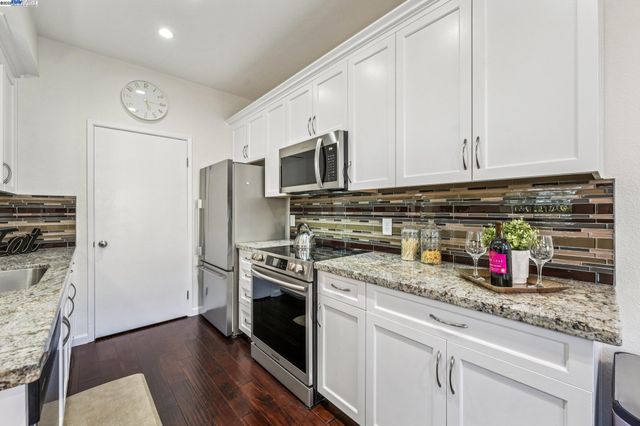 a kitchen with stainless steel appliances granite countertop a stove and a refrigerator