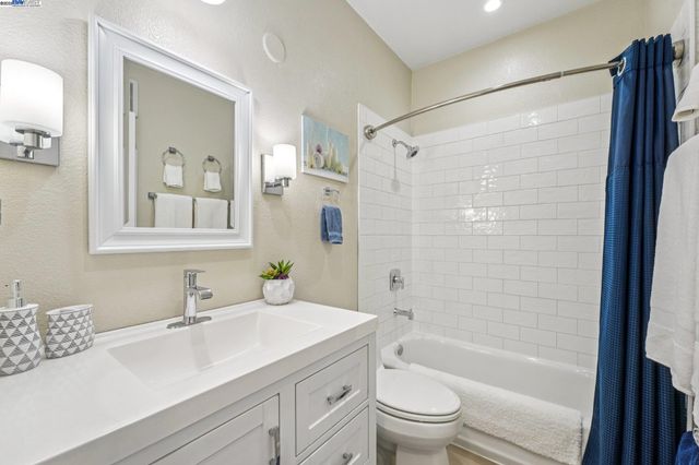 a bathroom with a sink a toilet and shower a mirror